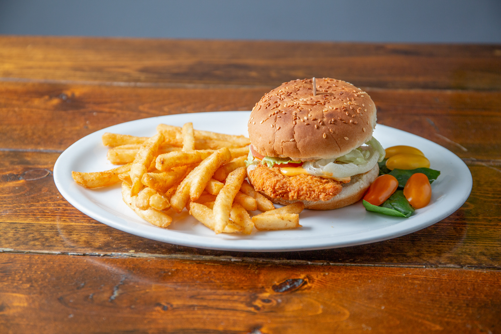 Crispy chicken burger with fries and fresh garnish