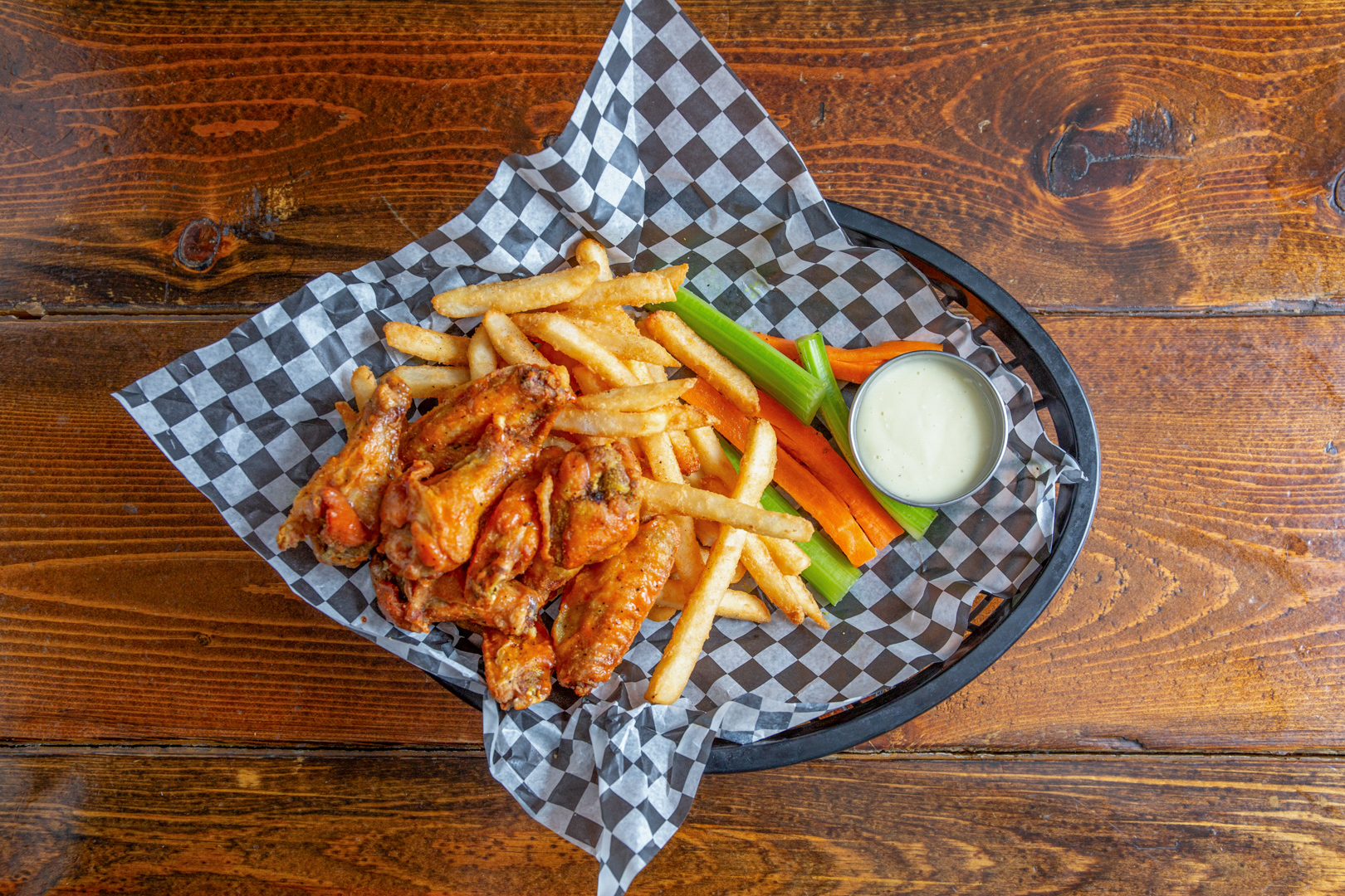 Saucy wings with ranch dip and herb garnish