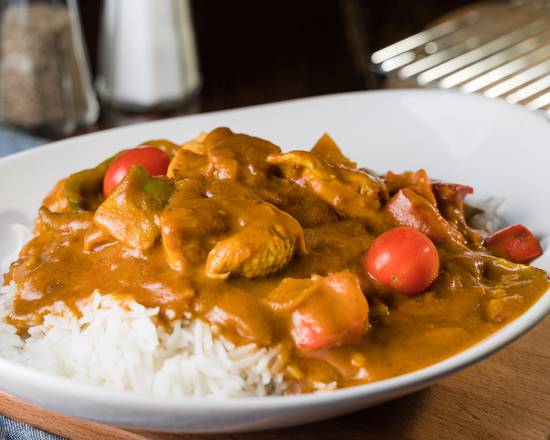 Butter chicken ladled over fragrant rice